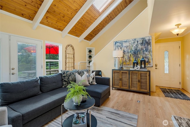 living room featuring a skylight, wood finished floors, high vaulted ceiling, and beam ceiling
