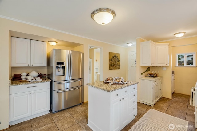 kitchen with crown molding, light stone counters, white cabinetry, and stainless steel refrigerator with ice dispenser