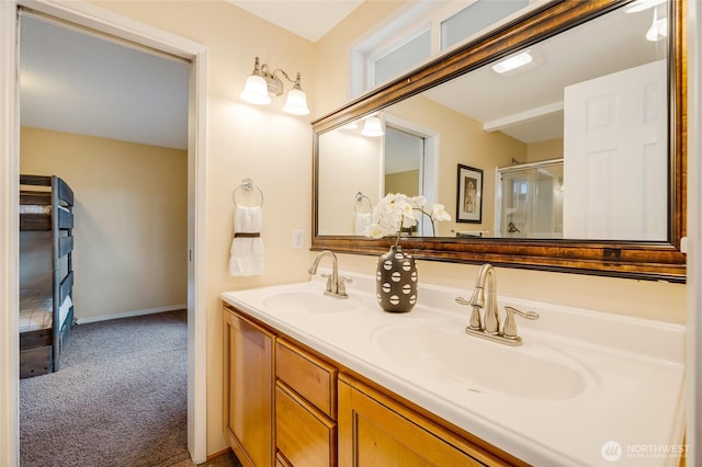 full bathroom featuring a shower with shower door, double vanity, baseboards, and a sink