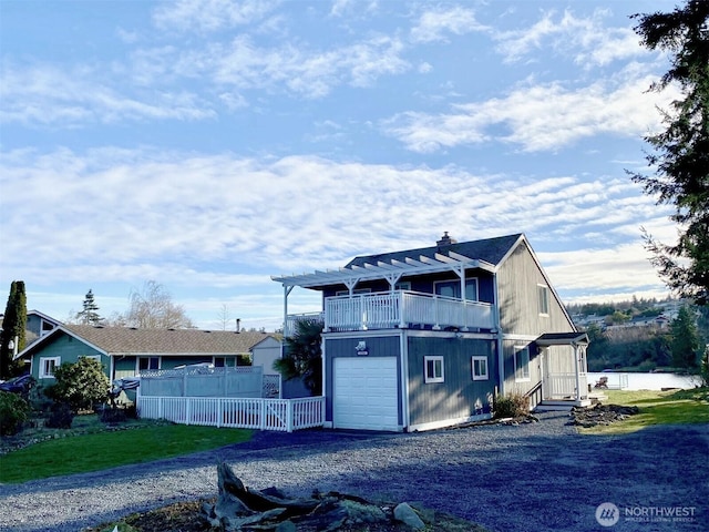 view of front of house featuring a garage, driveway, a pergola, and fence