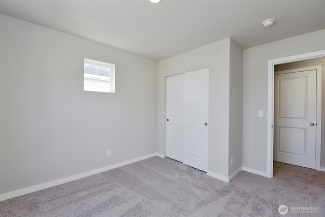 unfurnished bedroom featuring a closet and light carpet