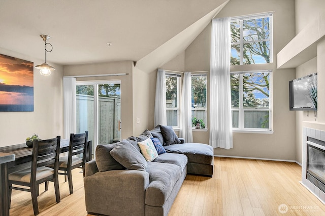 living area with light wood finished floors, a fireplace, and baseboards