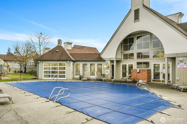 view of swimming pool featuring a fenced in pool, french doors, a patio area, and fence