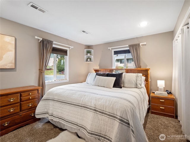 carpeted bedroom featuring multiple windows and visible vents