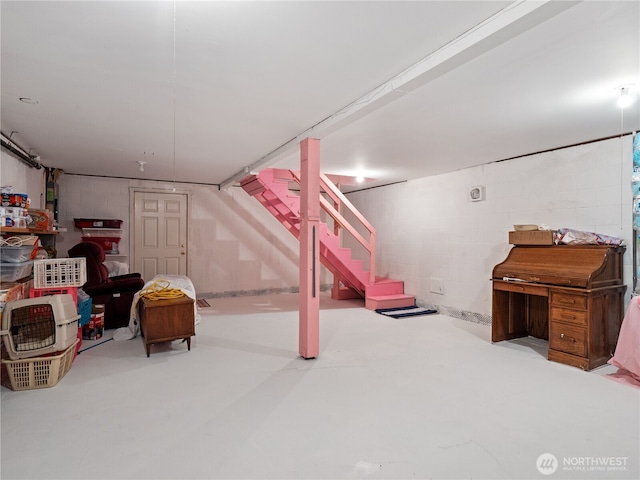 finished basement with stairs and concrete block wall