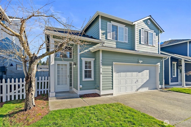 traditional-style home with driveway, a garage, and fence