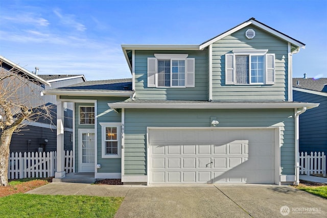 traditional-style house with a garage, concrete driveway, a shingled roof, and fence