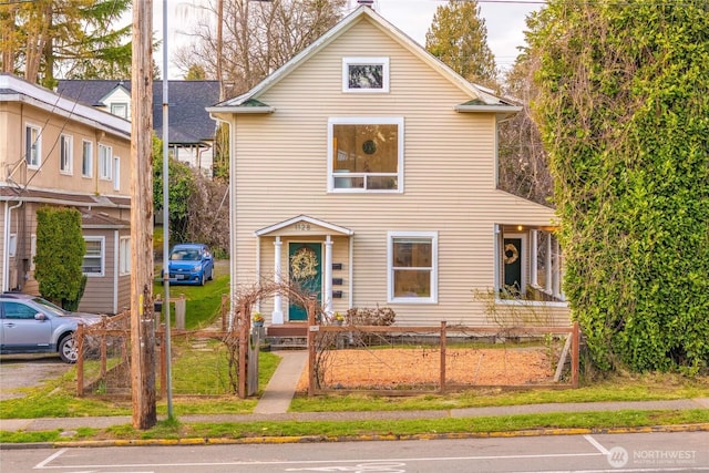 traditional-style house featuring a fenced front yard