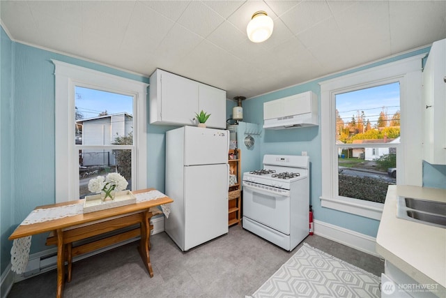 kitchen featuring baseboards, under cabinet range hood, light countertops, white appliances, and white cabinetry