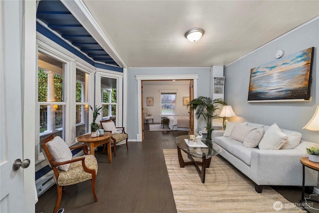 living room with a baseboard heating unit, wood-type flooring, and baseboards