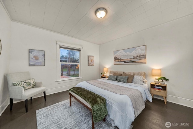 bedroom with baseboards and dark wood-style flooring