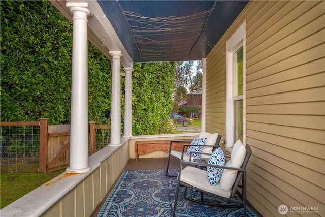 view of patio with a porch and fence