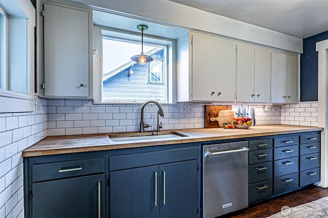 kitchen with hanging light fixtures, dark hardwood / wood-style flooring, sink, wood counters, and white cabinets