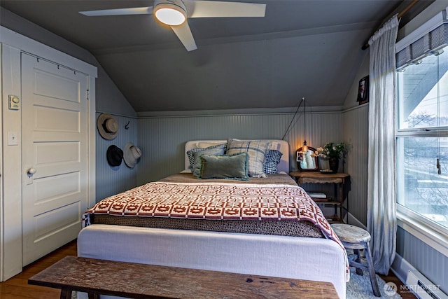 bedroom featuring baseboard heating, ceiling fan, vaulted ceiling, and hardwood / wood-style floors