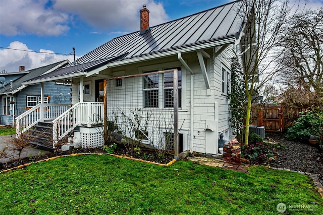 view of front facade featuring central AC and a front yard