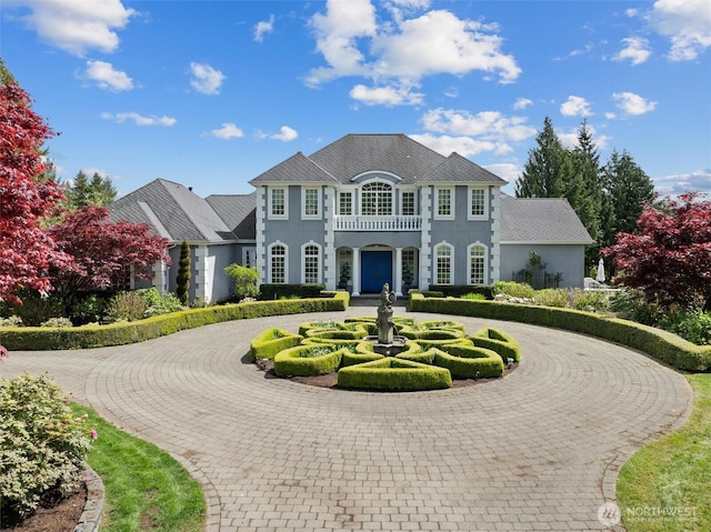 view of front facade with curved driveway and stucco siding