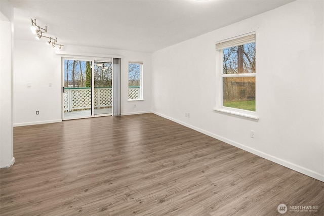 empty room with dark hardwood / wood-style floors and a healthy amount of sunlight