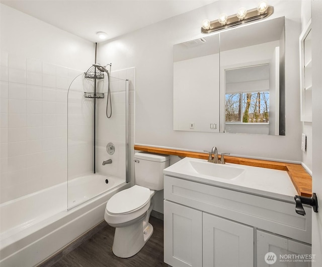 full bathroom featuring hardwood / wood-style flooring, vanity, toilet, and tiled shower / bath combo