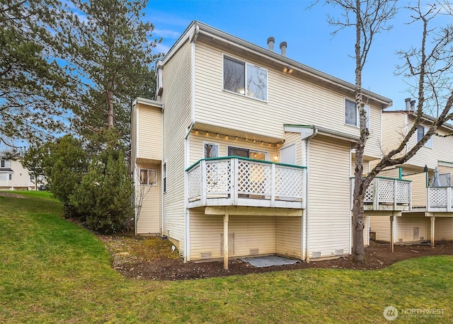 rear view of property featuring a lawn