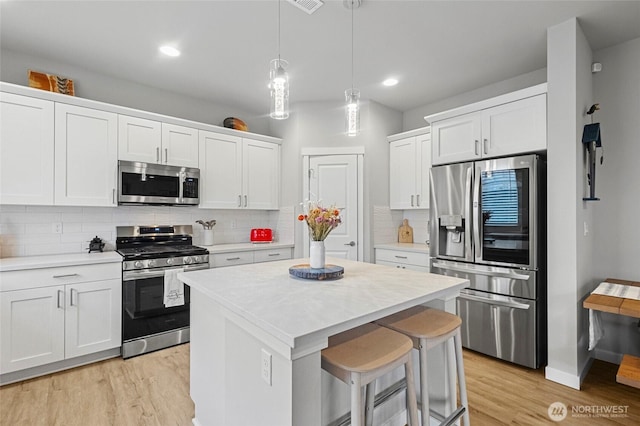 kitchen featuring light wood-type flooring, appliances with stainless steel finishes, and light countertops