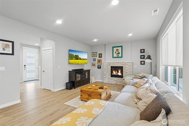 living room featuring light wood-style floors, baseboards, visible vents, and recessed lighting