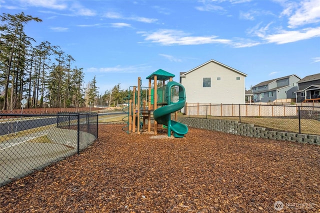 communal playground featuring fence and a residential view