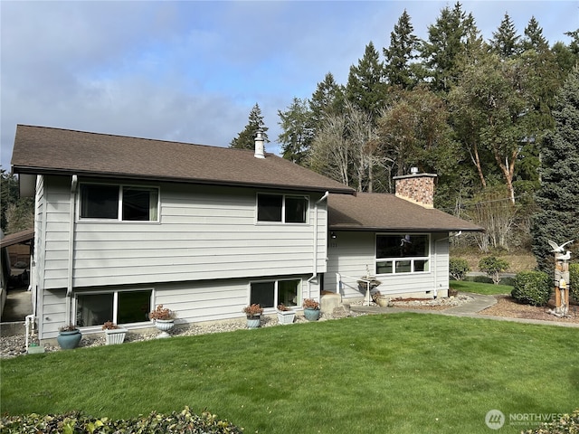 rear view of property with a chimney and a lawn