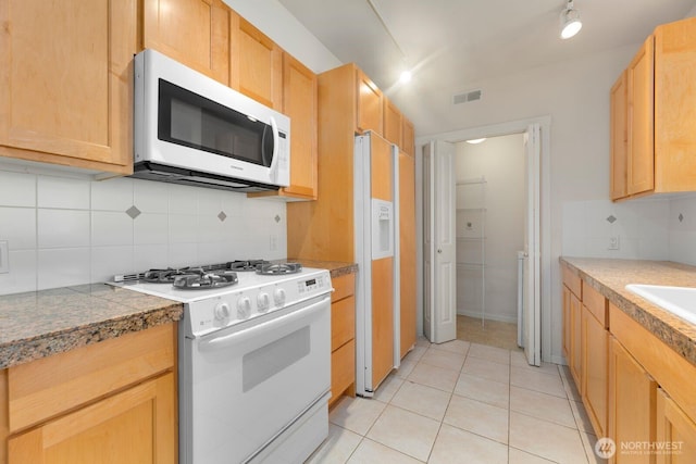 kitchen with visible vents, tasteful backsplash, white appliances, light tile patterned flooring, and tile counters