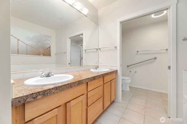 bathroom with a sink, a shower with shower door, toilet, and double vanity