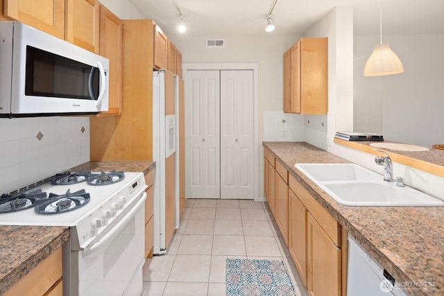 kitchen featuring a sink, visible vents, white appliances, and tasteful backsplash