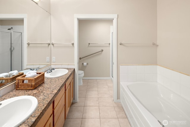 bathroom with tile patterned flooring, toilet, a bath, and a sink