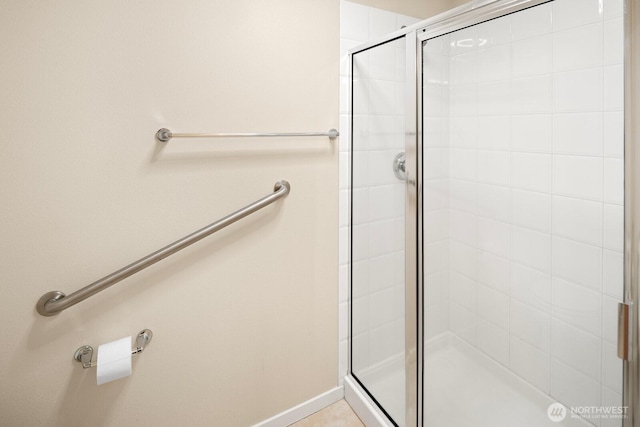 bathroom with baseboards and a stall shower