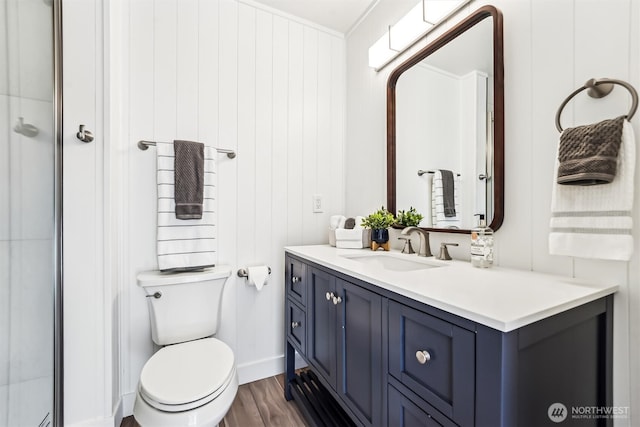 bathroom with toilet, wood finished floors, and vanity