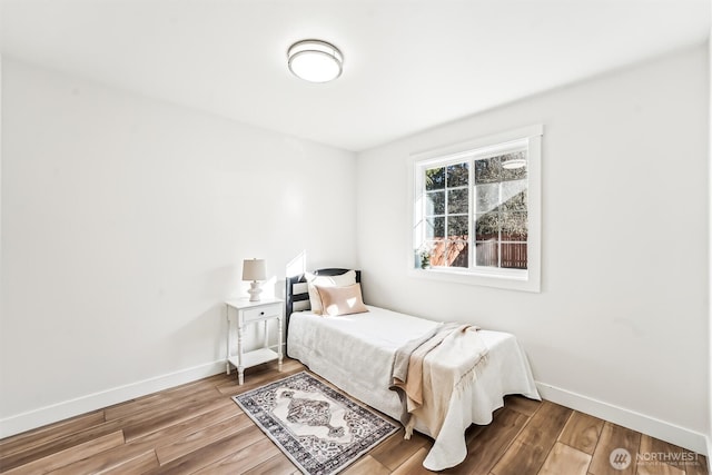 bedroom featuring baseboards and wood finished floors