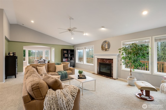 carpeted living room with ceiling fan, lofted ceiling, and a fireplace