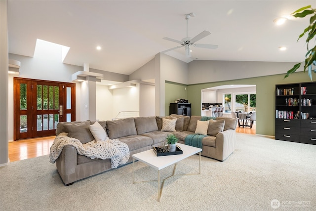 carpeted living room featuring ceiling fan and high vaulted ceiling