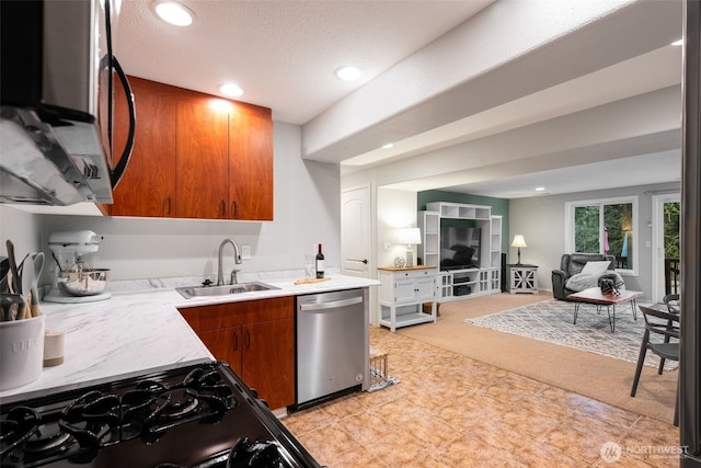 kitchen with light carpet, appliances with stainless steel finishes, sink, and a textured ceiling