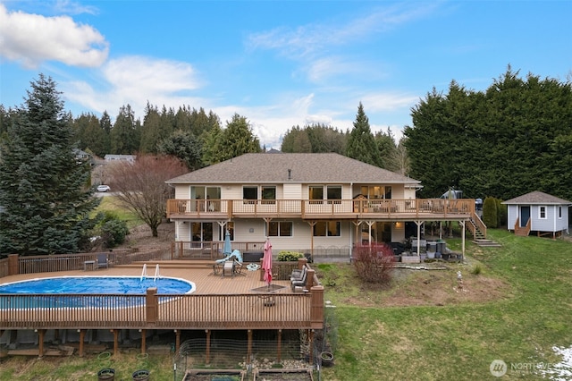 rear view of house featuring a yard, a storage unit, and a swimming pool side deck