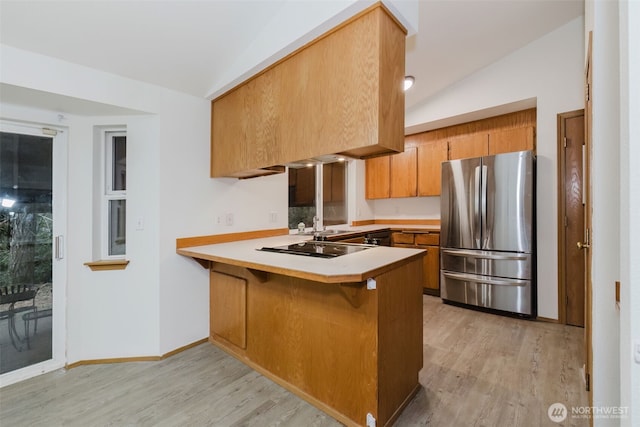 kitchen with lofted ceiling, stainless steel fridge, light hardwood / wood-style floors, kitchen peninsula, and black electric cooktop