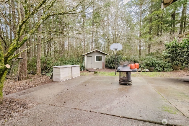 view of patio with a storage shed and a fire pit