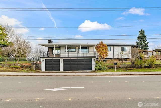 view of front facade featuring a garage and a balcony