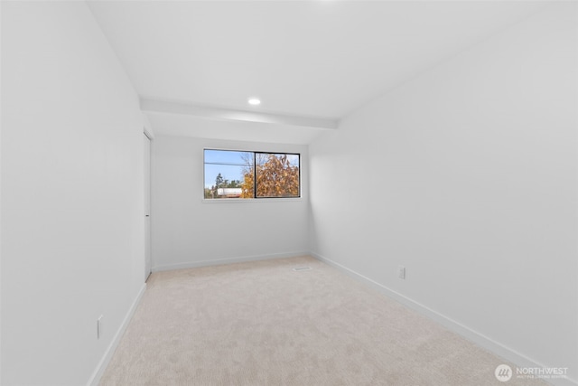 carpeted spare room featuring beamed ceiling