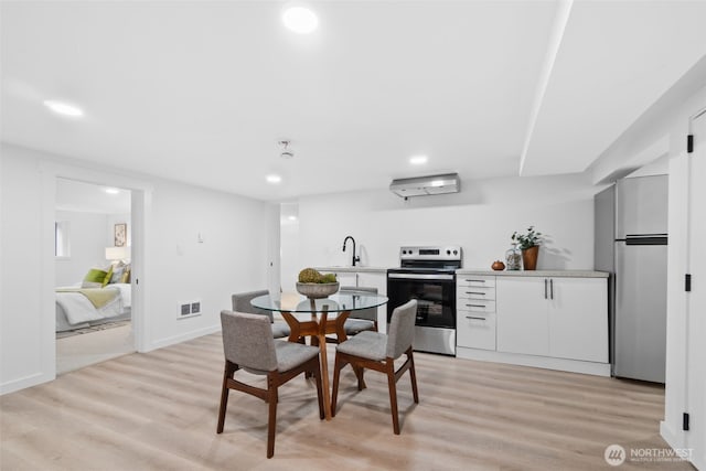 dining room featuring sink and light hardwood / wood-style floors