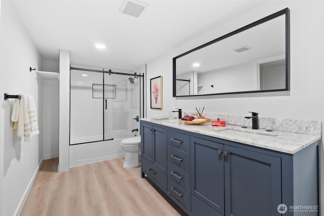 full bathroom featuring enclosed tub / shower combo, wood-type flooring, vanity, and toilet