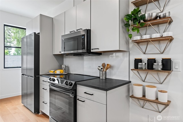 kitchen featuring backsplash, light hardwood / wood-style flooring, stainless steel appliances, and white cabinets