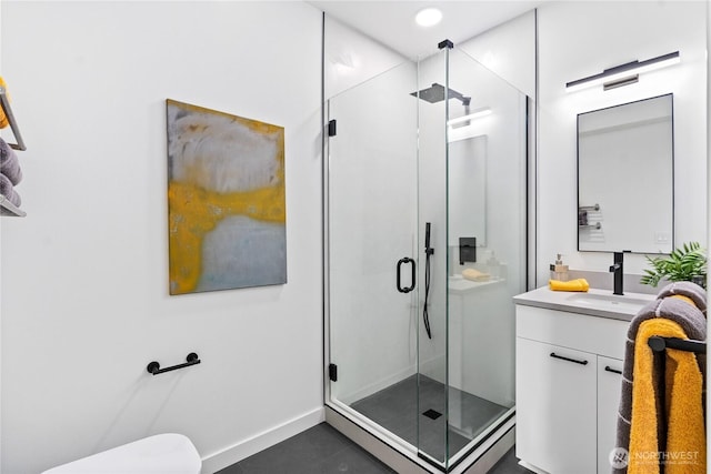 bathroom featuring a shower with door and vanity