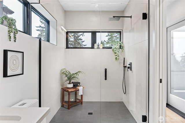 bathroom with a wealth of natural light and a shower with door