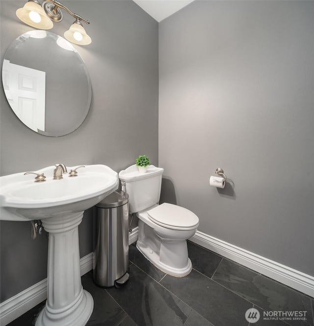 half bathroom featuring baseboards, toilet, and tile patterned floors