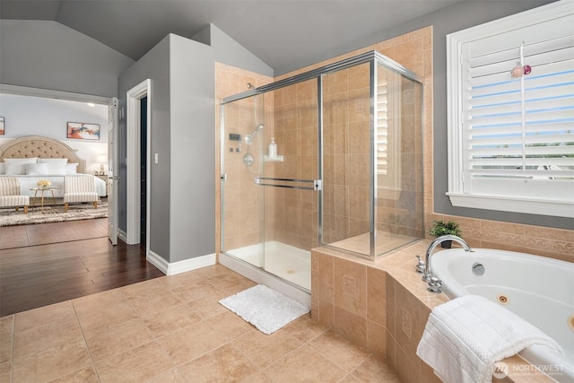 full bath featuring lofted ceiling, tile patterned flooring, baseboards, a tub with jets, and a stall shower