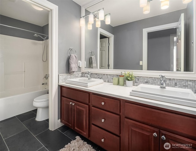 bathroom with tasteful backsplash, tile patterned flooring, and a sink